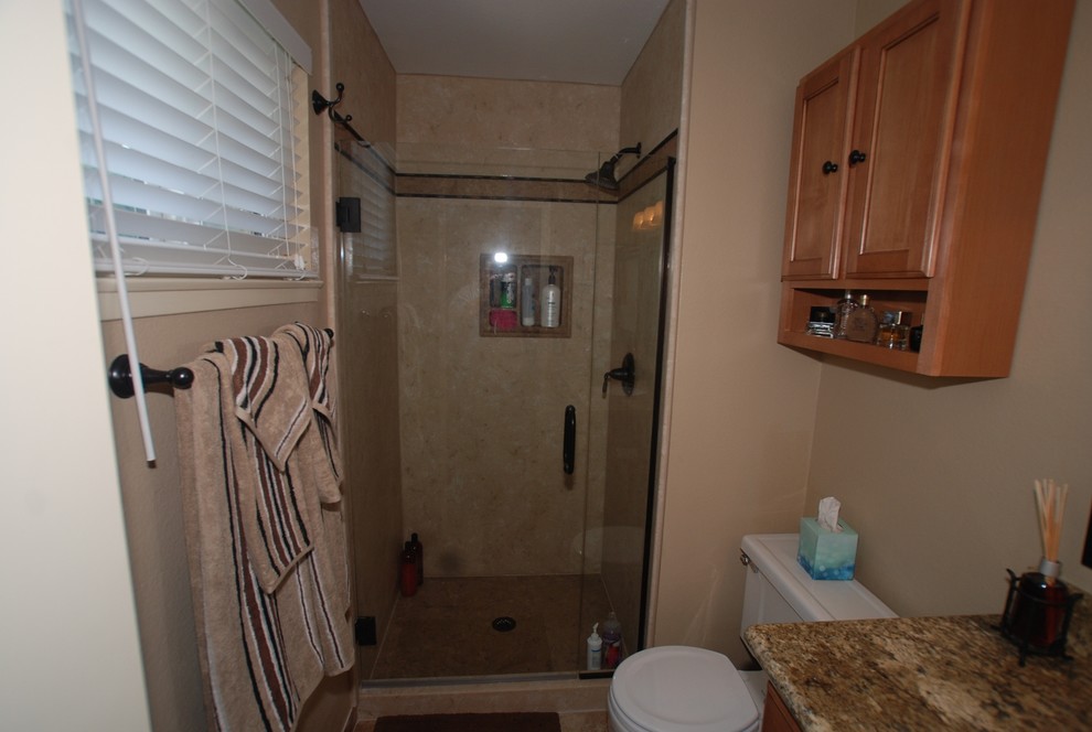 Example of a small 3/4 beige tile porcelain tile alcove shower design in Orange County with an undermount sink, raised-panel cabinets, light wood cabinets, granite countertops, a two-piece toilet and beige walls