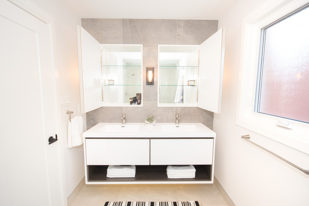 Exempel på ett stort modernt vit vitt badrum för barn, med släta luckor, vita skåp, en dubbeldusch, en toalettstol med hel cisternkåpa, grå kakel, porslinskakel, vita väggar, klinkergolv i porslin, ett integrerad handfat, bänkskiva i kvarts, grått golv och dusch med gångjärnsdörr