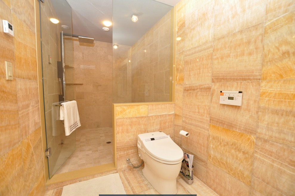 Modern inredning av ett stort en-suite badrum, med ett fristående handfat, släta luckor, skåp i ljust trä, bänkskiva i kvarts, ett fristående badkar, en öppen dusch, en toalettstol med hel cisternkåpa, gul kakel, stenkakel och gula väggar
