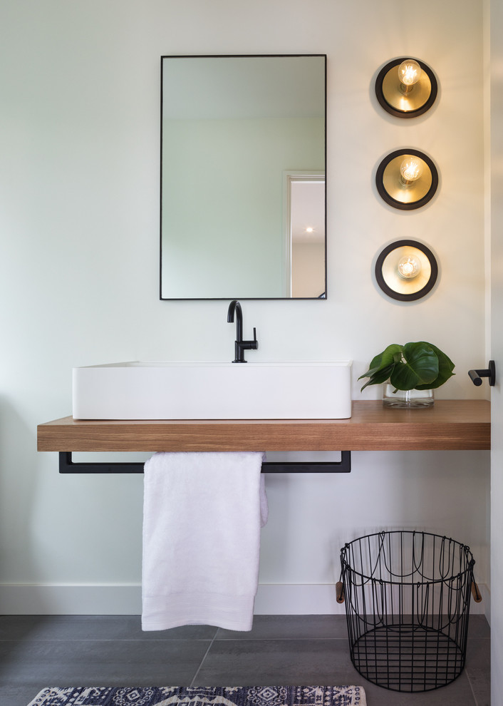 Imagen de cuarto de baño actual pequeño con paredes blancas, suelo de baldosas de porcelana, lavabo sobreencimera, encimera de madera y suelo gris