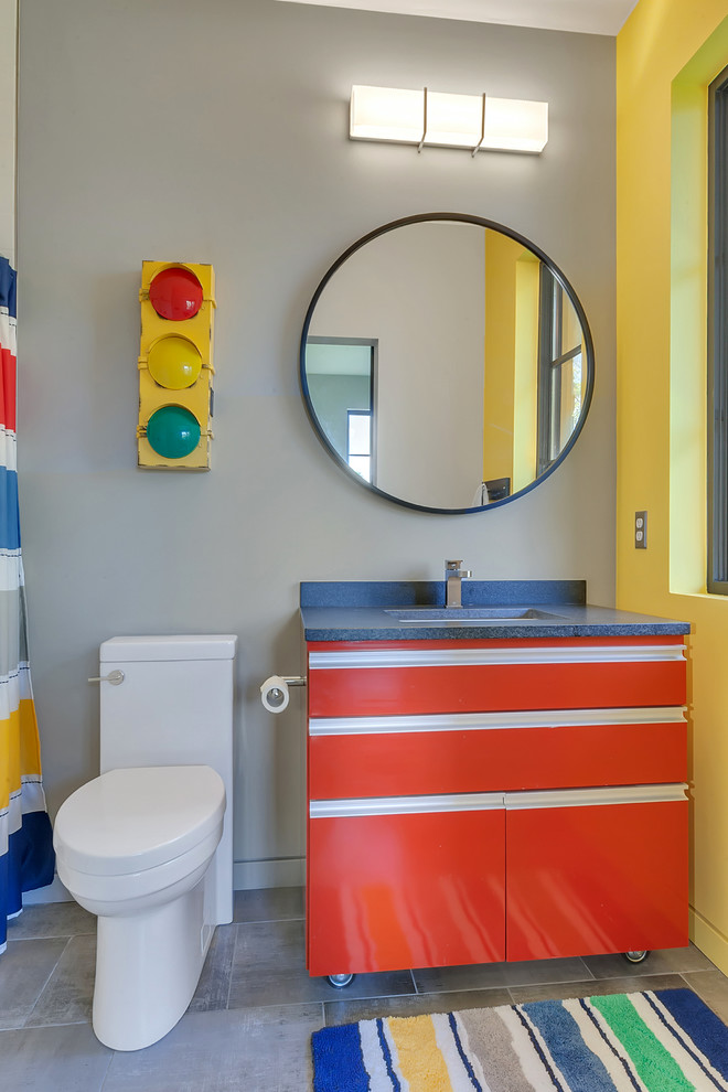 Foto di una piccola stanza da bagno per bambini minimal con ante rosse, pareti grigie, pavimento con piastrelle in ceramica, lavabo sottopiano, top in granito, ante lisce, WC monopezzo e pavimento grigio