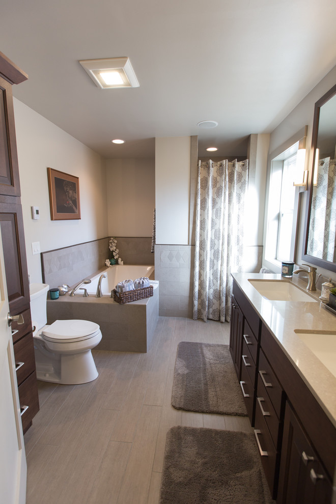 Пример оригинального дизайна: главная ванная комната среднего размера в стиле неоклассика (современная классика) с полновстраиваемой ванной, душем в нише, раздельным унитазом, серой плиткой, керамогранитной плиткой, серыми стенами, врезной раковиной, столешницей терраццо, серым полом, шторкой для ванной, темными деревянными фасадами, фасадами с выступающей филенкой и полом из керамогранита