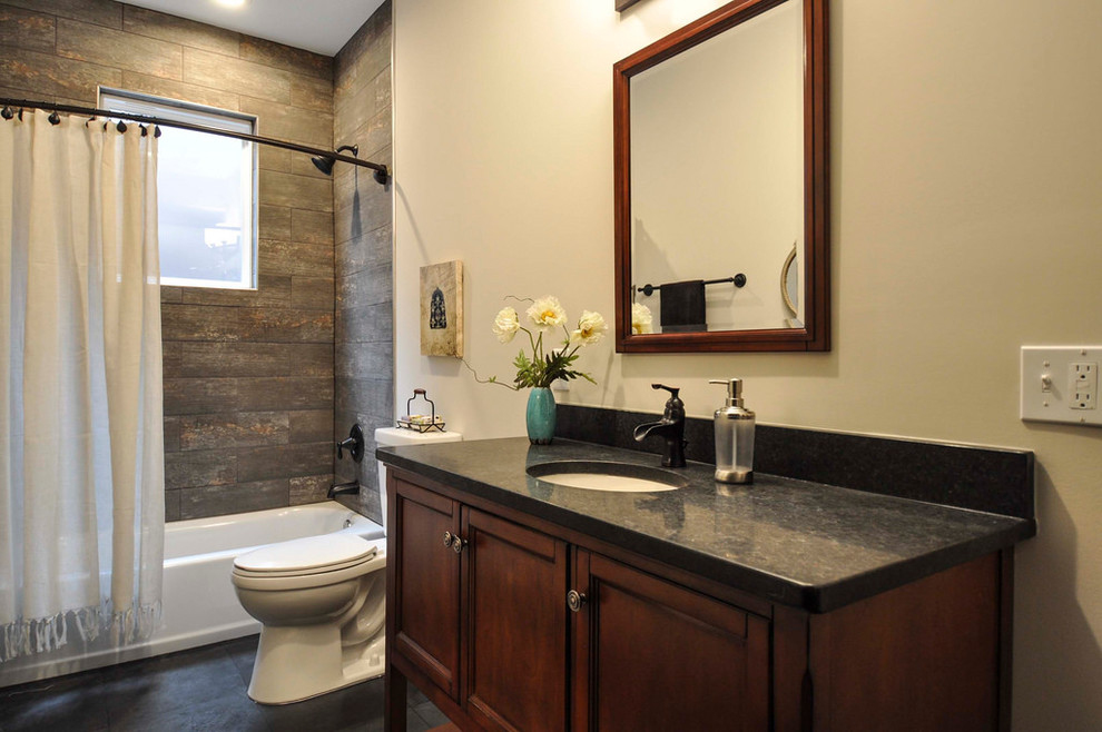 Large rustic family bathroom in St Louis with shaker cabinets, dark wood cabinets, a shower/bath combination, multi-coloured tiles, ceramic tiles, grey walls, slate flooring, an integrated sink, granite worktops, an alcove bath, a two-piece toilet, black floors and a shower curtain.