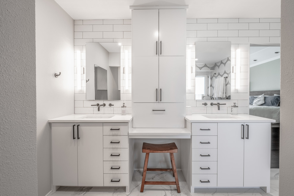 Photo of a large contemporary ensuite bathroom in Austin with flat-panel cabinets, white cabinets, a built-in bath, a two-piece toilet, ceramic tiles, white walls, marble flooring, a built-in sink, solid surface worktops, white floors and white worktops.