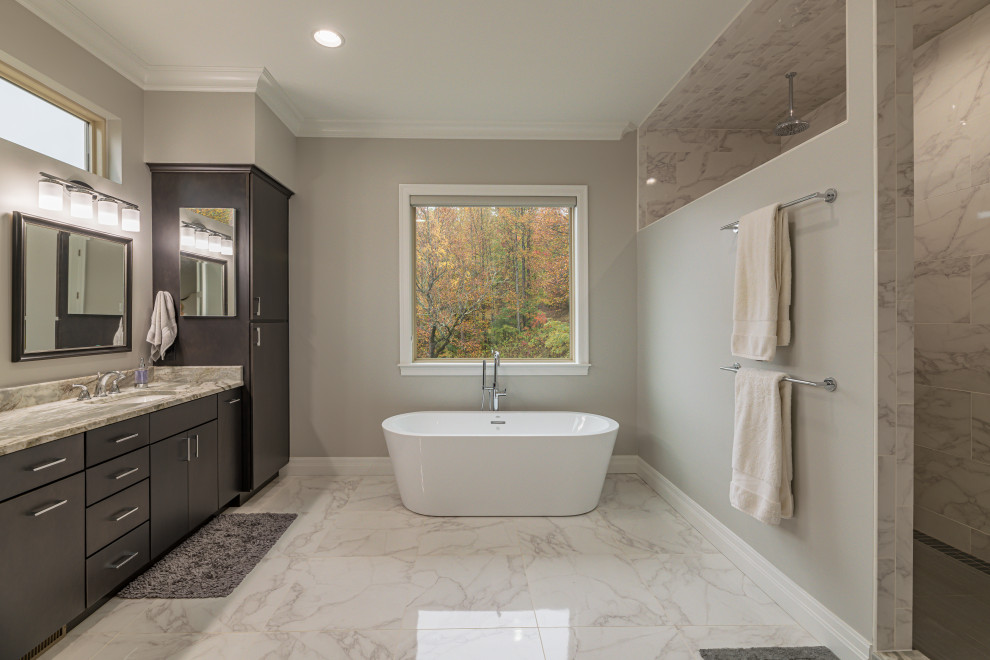 Photo of a large classic ensuite bathroom in Atlanta with flat-panel cabinets, black cabinets, a freestanding bath, an alcove shower, a two-piece toilet, grey tiles, ceramic tiles, beige walls, ceramic flooring, a submerged sink, granite worktops, grey floors, an open shower and multi-coloured worktops.
