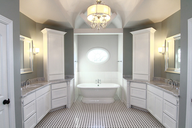 Uriges Badezimmer mit verzierten Schränken, weißen Schränken, freistehender Badewanne, Toilette mit Aufsatzspülkasten, Keramikboden, Granit-Waschbecken/Waschtisch und Falttür-Duschabtrennung in Louisville