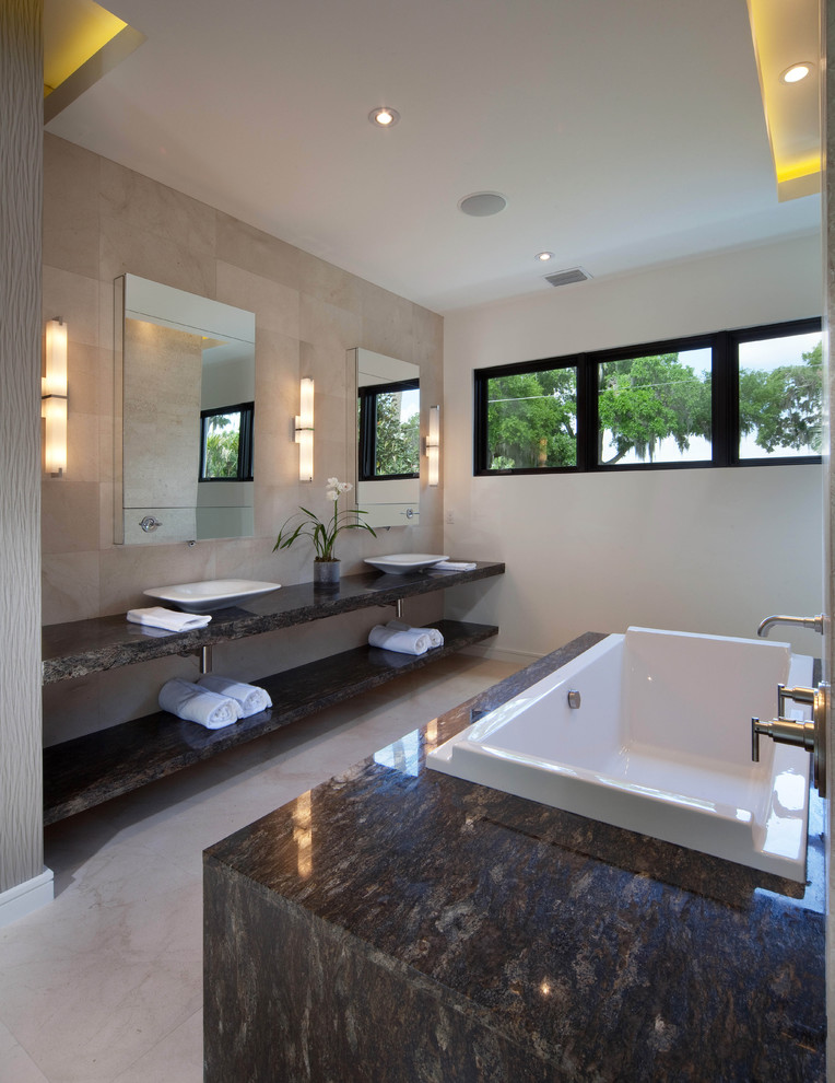 На фото: ванная комната в стиле модернизм с настольной раковиной и плиткой из известняка