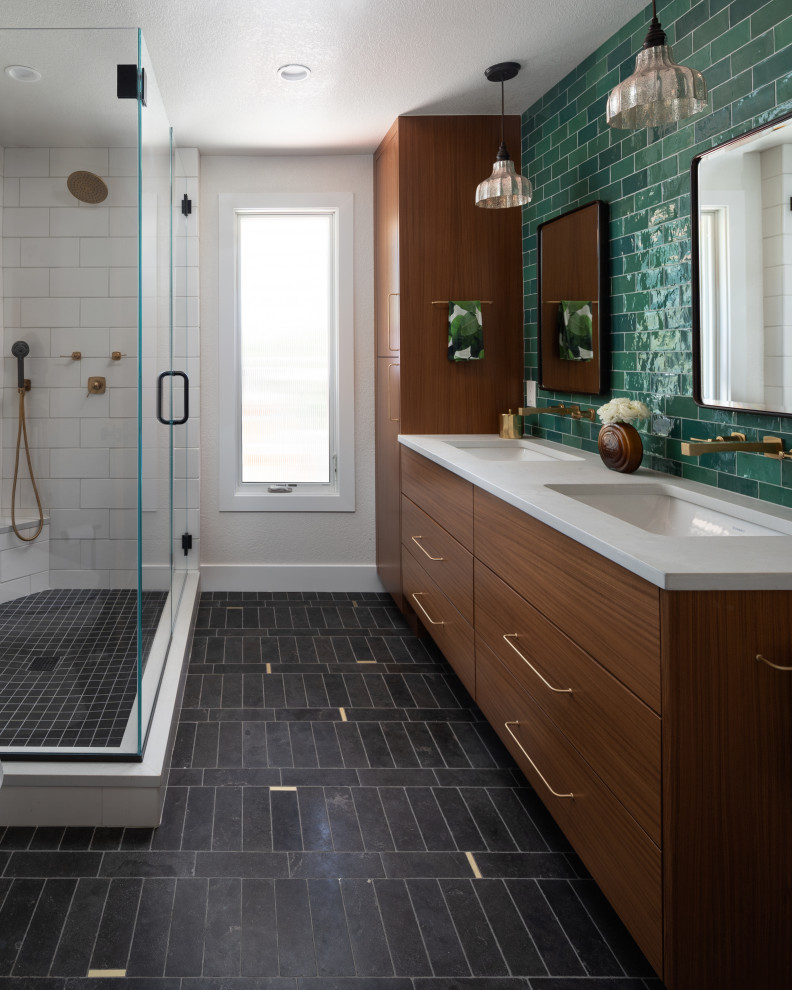 This is an example of a medium sized modern ensuite bathroom in Denver with flat-panel cabinets, medium wood cabinets, a corner shower, green tiles, ceramic tiles, a submerged sink, engineered stone worktops, black floors, a hinged door, white worktops, a wall niche, double sinks and a floating vanity unit.