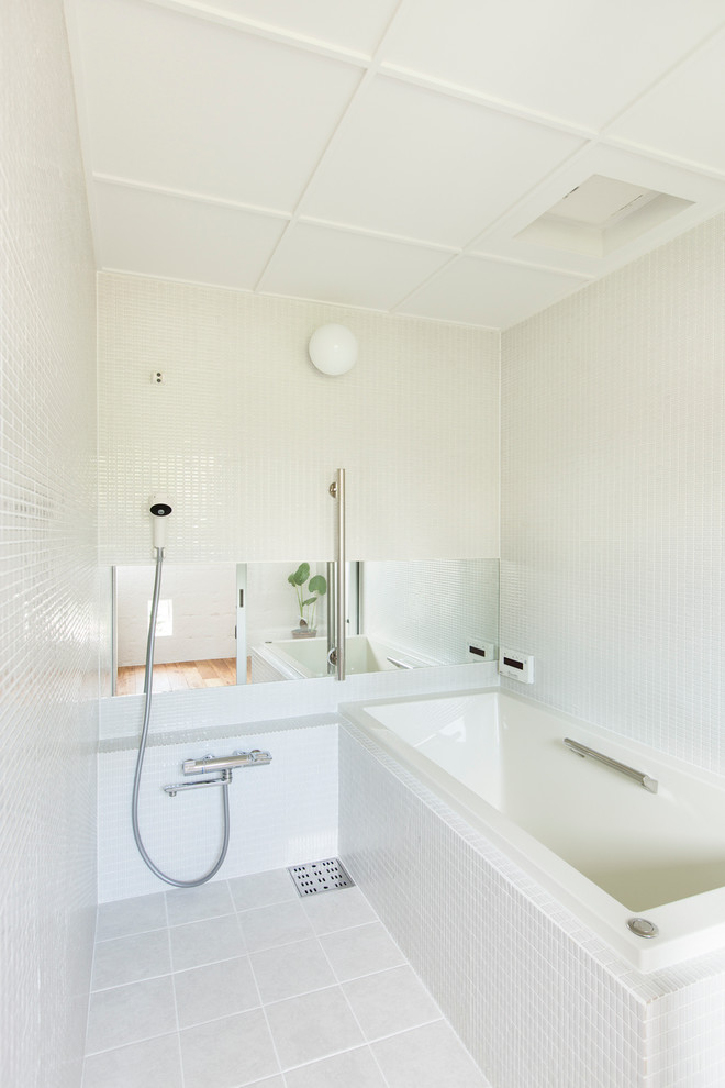 На фото: маленькая главная ванная комната в современном стиле с накладной ванной, белой плиткой, душевой комнатой, плиткой мозаикой, белыми стенами, белым полом и открытым душем для на участке и в саду