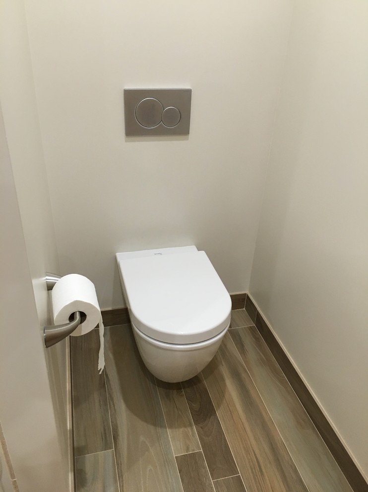 Design ideas for a medium sized beach style cloakroom in Hawaii with shaker cabinets, dark wood cabinets, a wall mounted toilet, beige tiles, porcelain tiles, white walls, porcelain flooring, a submerged sink, quartz worktops and brown floors.