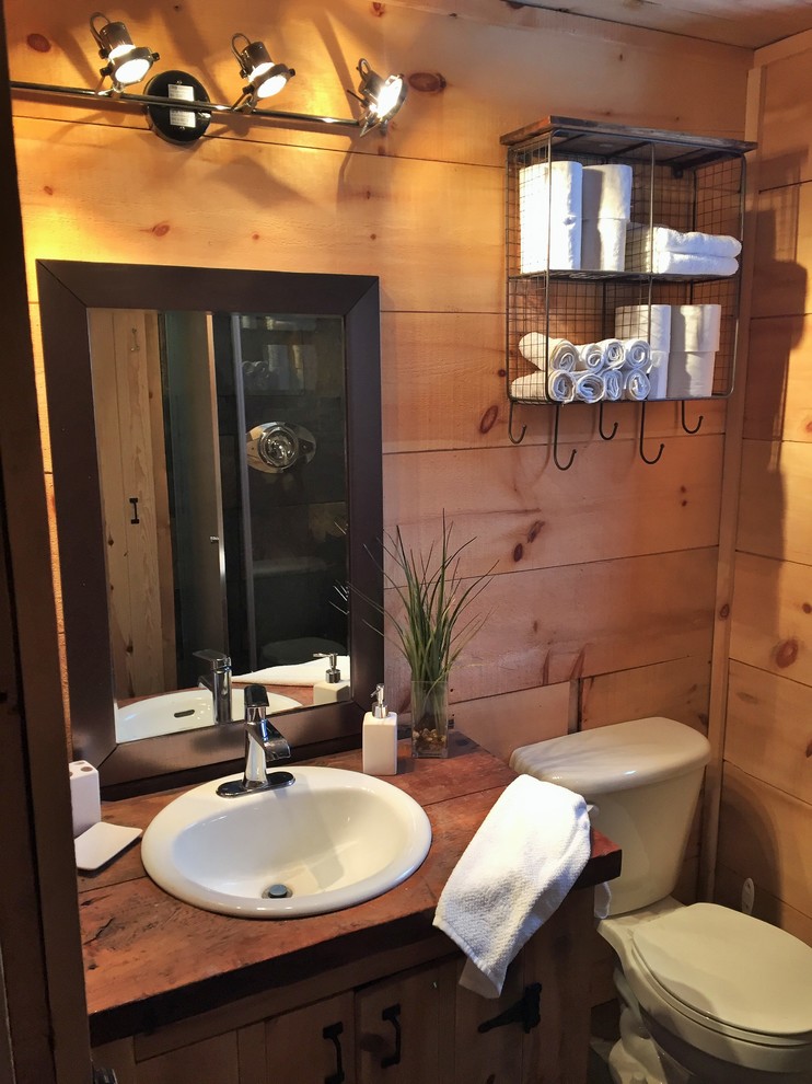 Idéer för ett litet rustikt brun badrum med dusch, med släta luckor, skåp i slitet trä, en hörndusch, en toalettstol med hel cisternkåpa, grå kakel, stenkakel, skiffergolv, ett nedsänkt handfat, träbänkskiva och bruna väggar