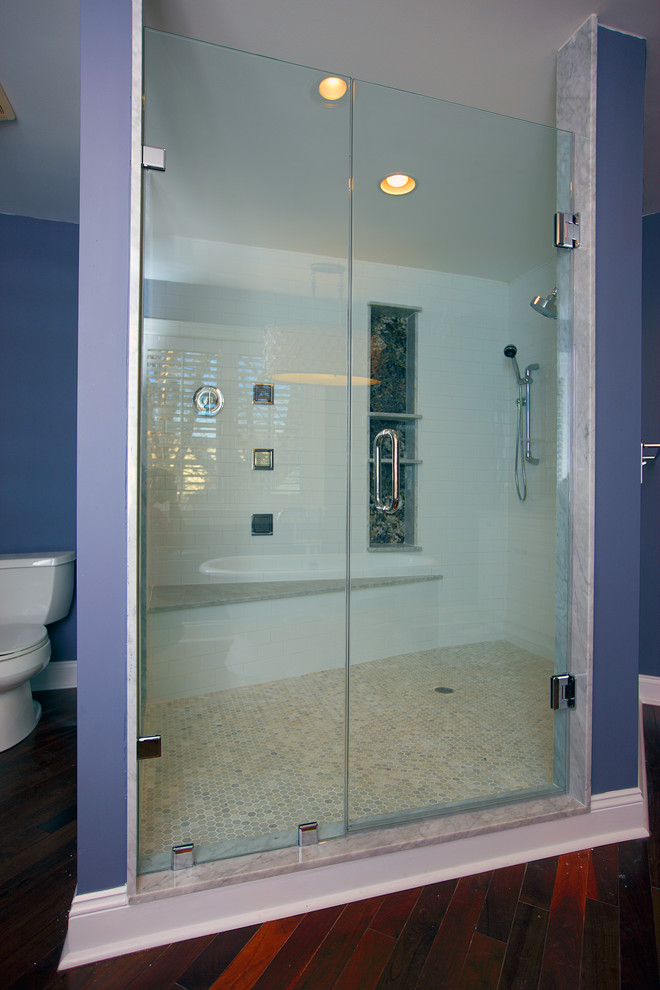 На фото: большая главная ванная комната в стиле модернизм с душем в нише, душем с распашными дверями, унитазом-моноблоком, белой плиткой, мраморной плиткой, синими стенами, темным паркетным полом и коричневым полом