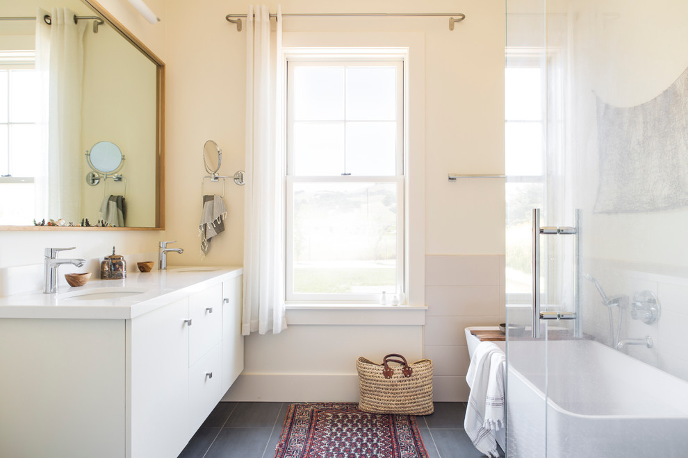 Esempio di una grande stanza da bagno padronale country con ante lisce, ante bianche, doccia ad angolo, pareti beige, pavimento in gres porcellanato, lavabo sottopiano, pavimento grigio e porta doccia a battente