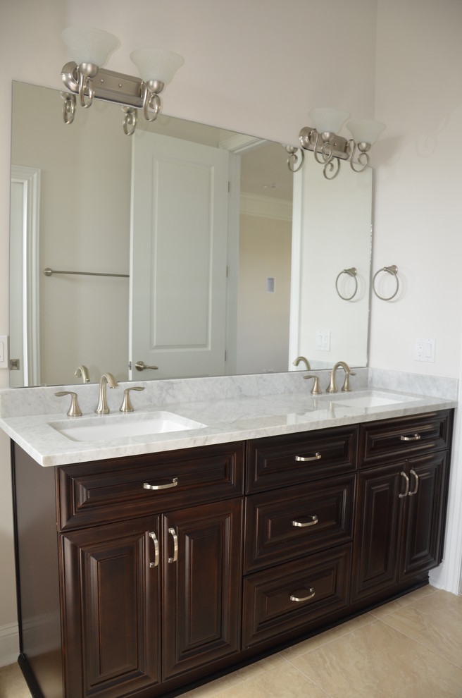 Design ideas for a large classic ensuite bathroom in Jacksonville with raised-panel cabinets, dark wood cabinets, white walls, porcelain flooring, a submerged sink, marble worktops and beige floors.