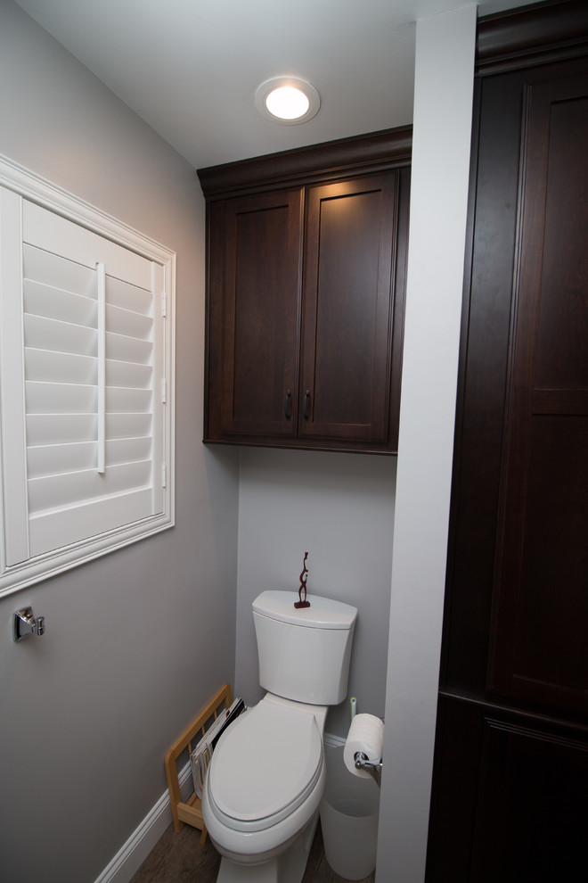 Exemple d'une salle de bain principale chic en bois foncé de taille moyenne avec un lavabo encastré, un placard à porte plane, un plan de toilette en quartz modifié, un carrelage blanc, un carrelage métro et un mur gris.