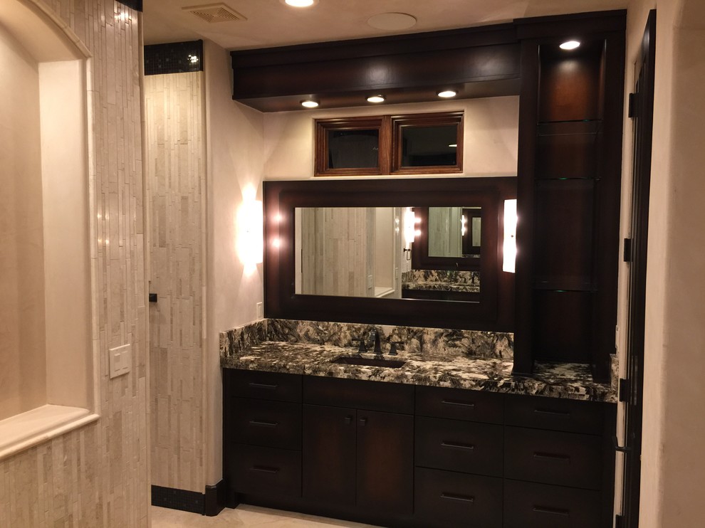 Imagen de cuarto de baño principal mediterráneo con armarios con paneles lisos, puertas de armario de madera en tonos medios y encimera de granito