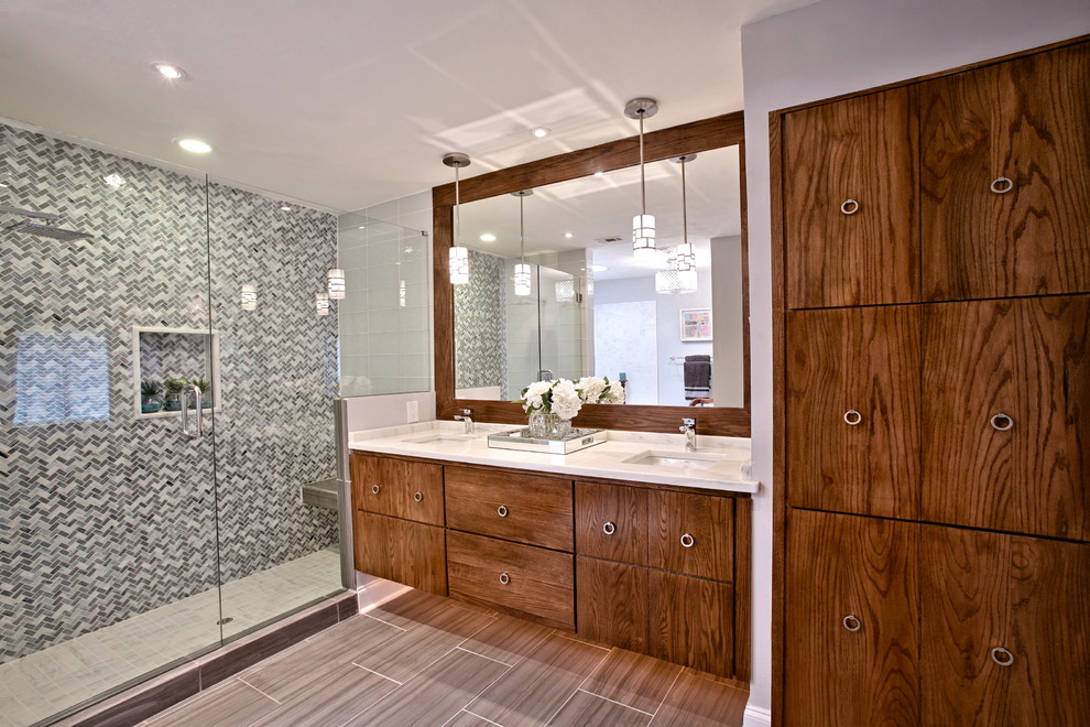Réalisation d'une salle de bain principale design en bois brun de taille moyenne avec un lavabo encastré, un placard à porte plane, un plan de toilette en marbre, une baignoire posée, une douche double, WC séparés, un carrelage gris, un mur gris et un sol en carrelage de porcelaine.