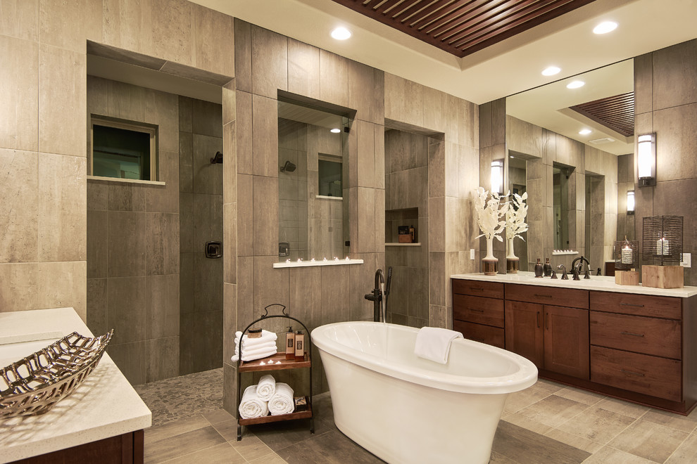 Idée de décoration pour une salle de bain principale tradition en bois brun avec un placard à porte shaker, une baignoire indépendante, une douche double, un carrelage gris, un lavabo encastré, un sol gris, aucune cabine et un plan de toilette beige.