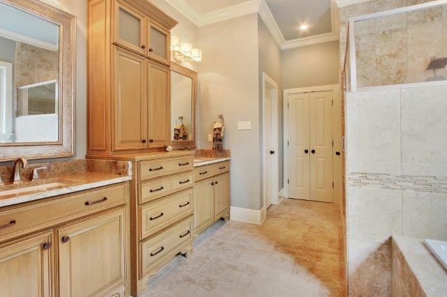 Idées déco pour une salle de bain principale contemporaine en bois brun avec un placard avec porte à panneau surélevé, une baignoire posée, une douche d'angle, un carrelage beige, du carrelage en pierre calcaire, un mur gris, un sol en calcaire, un lavabo encastré, un plan de toilette en granite, un sol beige, une cabine de douche à porte battante et un plan de toilette beige.