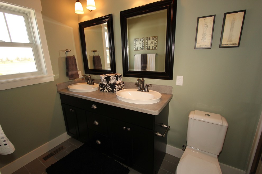 Foto di una piccola stanza da bagno padronale tradizionale con lavabo a bacinella, ante con riquadro incassato, ante nere, top in laminato, WC a due pezzi, pareti verdi e pavimento in gres porcellanato