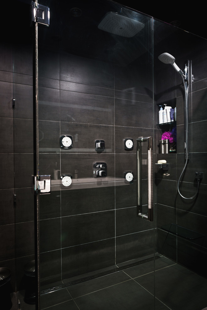 Exempel på ett modernt badrum med dusch, med släta luckor, svarta skåp, en dusch i en alkov, svart kakel, keramikplattor, svarta väggar, ett avlångt handfat, bänkskiva i glas, klinkergolv i keramik och svart golv