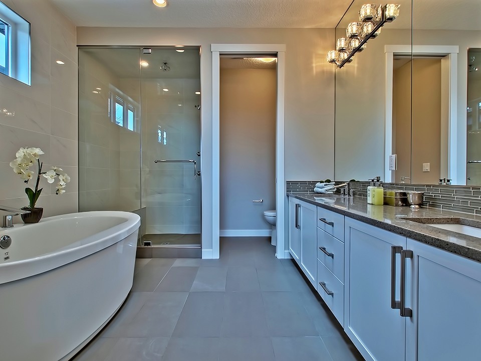 Immagine di una grande stanza da bagno padronale moderna con lavabo sottopiano, ante in stile shaker, ante bianche, vasca freestanding, doccia ad angolo e pareti beige