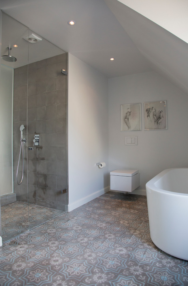 Inspiration för stora moderna en-suite badrum, med släta luckor, vita skåp, ett fristående badkar, en öppen dusch, en vägghängd toalettstol, blå kakel, vita väggar och mosaikgolv