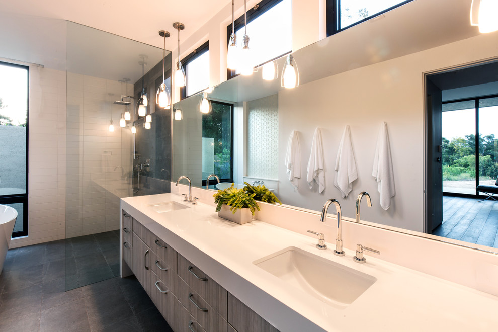 Пример оригинального дизайна: главная ванная комната среднего размера в современном стиле с плоскими фасадами, светлыми деревянными фасадами, отдельно стоящей ванной, открытым душем, белой плиткой, стеклянной плиткой, белыми стенами, полом из керамогранита, монолитной раковиной и столешницей из искусственного кварца