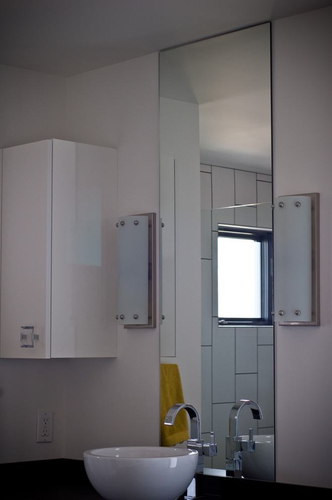 Imagen de cuarto de baño minimalista con lavabo sobreencimera, armarios con paneles lisos y puertas de armario grises