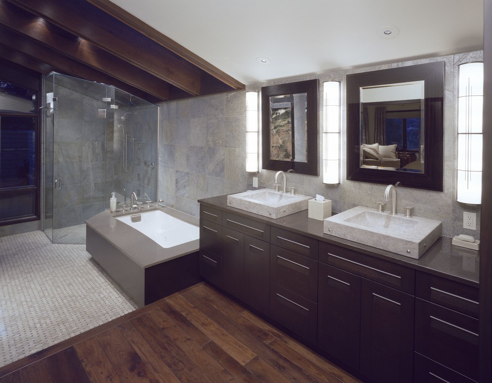 На фото: большая ванная комната в современном стиле с настольной раковиной, плоскими фасадами, темными деревянными фасадами, душем без бортиков, серой плиткой и паркетным полом среднего тона
