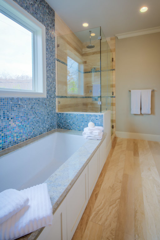 Inredning av ett modernt stort en-suite badrum, med granitbänkskiva, ett undermonterat badkar, en hörndusch, beige kakel, stenkakel, beige väggar och travertin golv