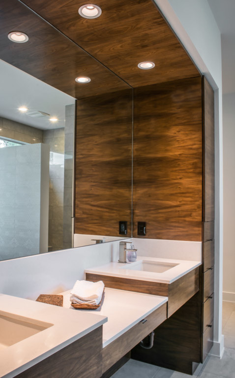 Cette image montre une grande salle de bain principale minimaliste en bois brun avec un lavabo encastré, un placard à porte plane, un plan de toilette en quartz modifié, un carrelage gris, des carreaux de céramique, un mur blanc et un sol en carrelage de céramique.