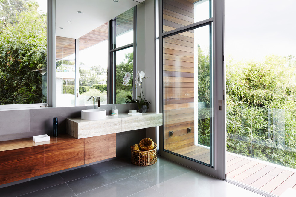 Стильный дизайн: ванная комната в современном стиле с настольной раковиной, плоскими фасадами, фасадами цвета дерева среднего тона, серыми стенами, серой плиткой, полом из керамической плитки и столешницей из дерева - последний тренд