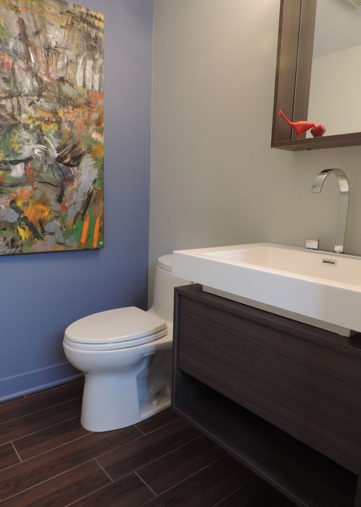 Inspiration for a small modern bathroom in Chicago with flat-panel cabinets, dark wood cabinets, a one-piece toilet, grey walls, a vessel sink and ceramic flooring.