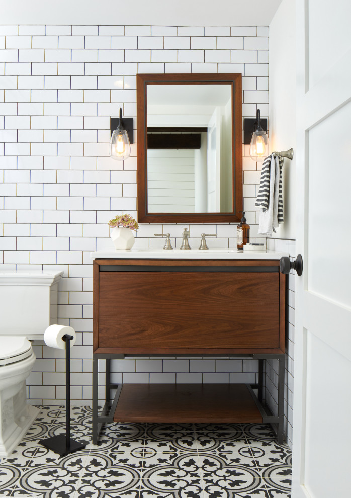 Foto på ett mellanstort funkis vit badrum, med möbel-liknande, skåp i mellenmörkt trä, en öppen dusch, en toalettstol med hel cisternkåpa, vit kakel, keramikplattor, vita väggar, cementgolv, ett konsol handfat, marmorbänkskiva, flerfärgat golv och med dusch som är öppen