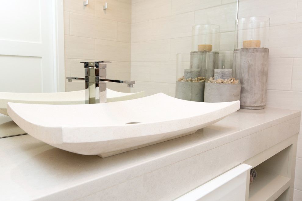 Esempio di una stanza da bagno con doccia design di medie dimensioni con ante lisce, ante bianche, doccia alcova, piastrelle di ciottoli, pareti beige e lavabo a bacinella