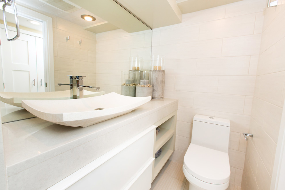 Cette photo montre une salle de bain tendance de taille moyenne avec un placard à porte plane, des portes de placard blanches, une plaque de galets, un mur beige et une vasque.