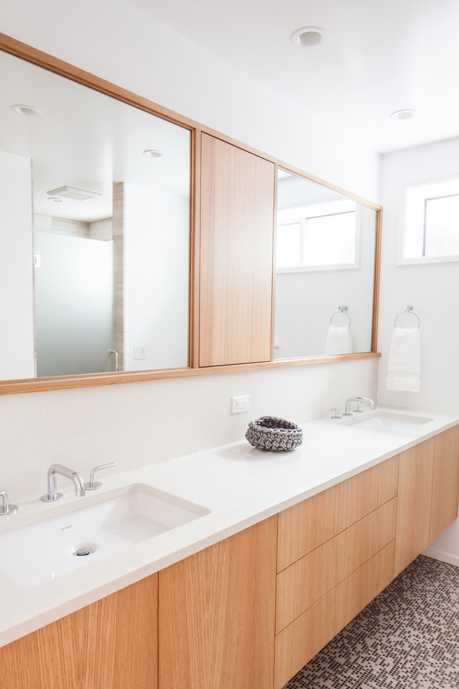 На фото: детская ванная комната среднего размера в стиле модернизм с белыми стенами, врезной раковиной, плоскими фасадами, светлыми деревянными фасадами и столешницей из искусственного кварца с