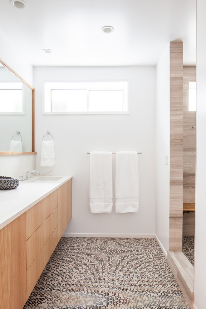 Cette photo montre une salle de bain moderne en bois clair avec un lavabo encastré, un placard à porte plane, un plan de toilette en quartz modifié, une douche d'angle, un mur blanc et un sol en carrelage de terre cuite.