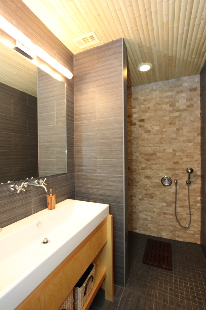 Idéer för små funkis en-suite badrum, med möbel-liknande, skåp i ljust trä, en kantlös dusch, brun kakel, keramikplattor, bruna väggar, klinkergolv i keramik, ett avlångt handfat, brunt golv och med dusch som är öppen