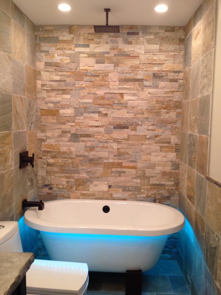 Example of a mid-sized minimalist green tile and stone tile slate floor freestanding bathtub design in Charlotte with a vessel sink, recessed-panel cabinets, dark wood cabinets, concrete countertops, a one-piece toilet and green walls