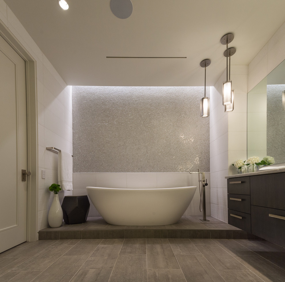 Diseño de cuarto de baño principal moderno extra grande con bañera exenta, baldosas y/o azulejos grises y paredes blancas