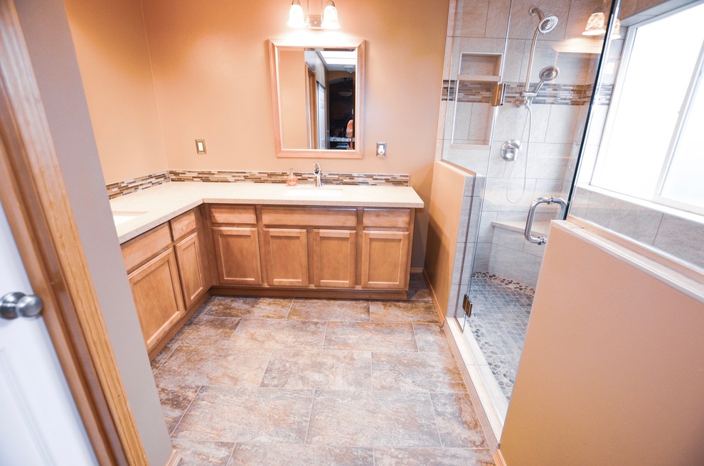 Mid-sized minimalist master white tile and marble tile cement tile floor and brown floor double shower photo in Seattle with raised-panel cabinets, light wood cabinets, orange walls, a drop-in sink, marble countertops, a hinged shower door and beige countertops