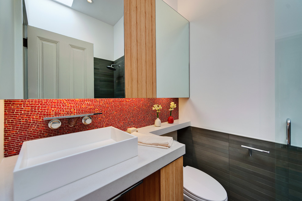 Inredning av ett modernt mellanstort badrum med dusch, med mosaik, ett fristående handfat, röd kakel, släta luckor, skåp i mellenmörkt trä, en toalettstol med separat cisternkåpa, vita väggar och bänkskiva i kvarts