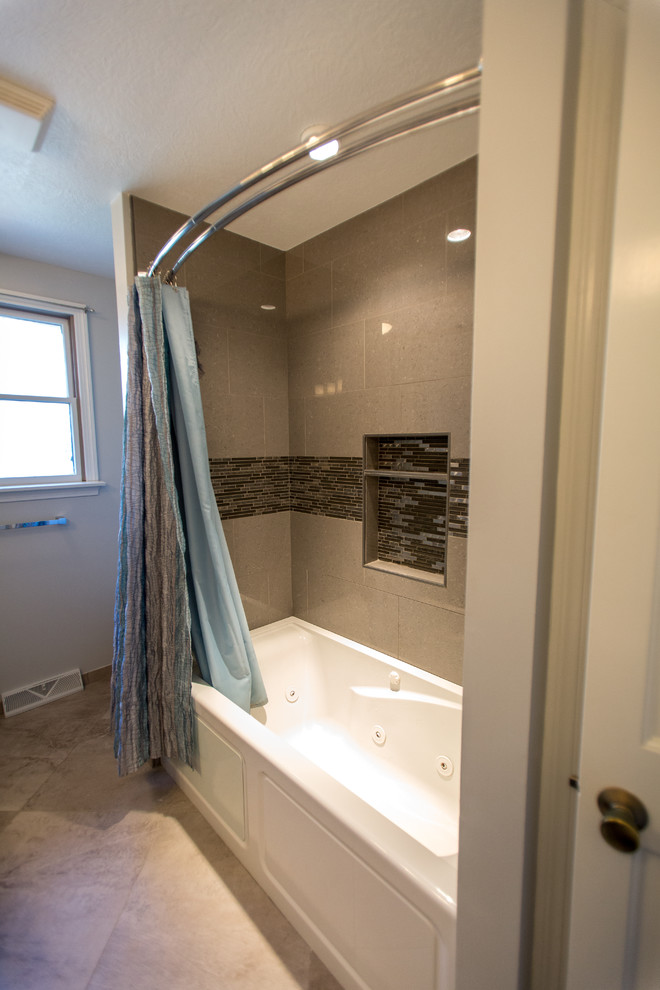 Exemple d'une salle de bain tendance de taille moyenne pour enfant avec un placard avec porte à panneau surélevé, des portes de placard noires, une baignoire en alcôve, un carrelage gris, des carreaux de porcelaine, un mur gris, un sol en carrelage de porcelaine, un lavabo encastré et un plan de toilette en granite.