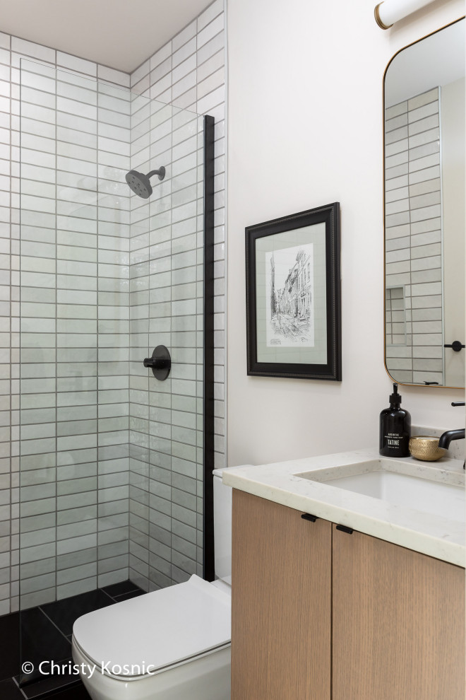 Inspiration för mellanstora moderna vitt badrum, med släta luckor, skåp i ljust trä, en öppen dusch, en toalettstol med separat cisternkåpa, grå kakel, keramikplattor, vita väggar, klinkergolv i porslin, ett väggmonterat handfat, bänkskiva i kvarts, svart golv och med dusch som är öppen