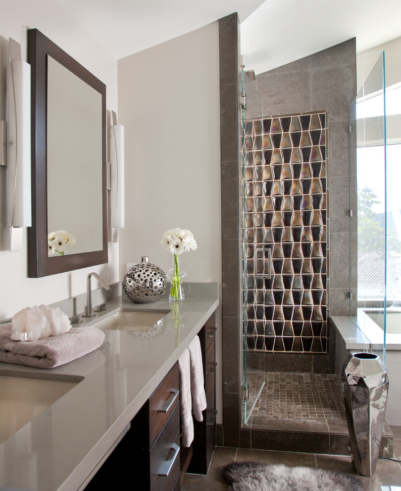 На фото: ванная комната в современном стиле с врезной раковиной, плоскими фасадами, темными деревянными фасадами, полновстраиваемой ванной, угловым душем, серой плиткой, белыми стенами и серой столешницей с
