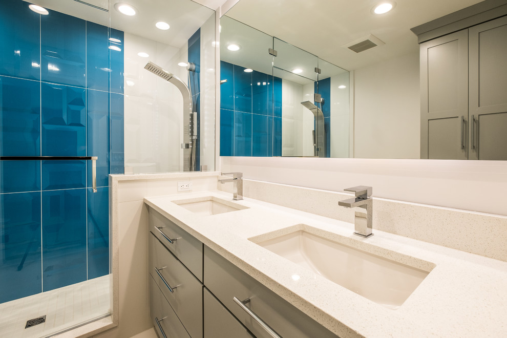 Ispirazione per una stanza da bagno padronale minimalista di medie dimensioni con ante lisce, ante grigie, doccia alcova, WC monopezzo, piastrelle blu, piastrelle di vetro, pareti bianche, lavabo sottopiano, top in quarzite, pavimento bianco e porta doccia a battente