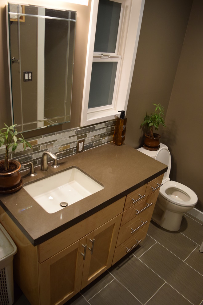 Imagen de cuarto de baño moderno pequeño con lavabo bajoencimera, armarios estilo shaker, puertas de armario de madera oscura, encimera de cuarcita, baldosas y/o azulejos grises, baldosas y/o azulejos de vidrio y suelo de baldosas de porcelana