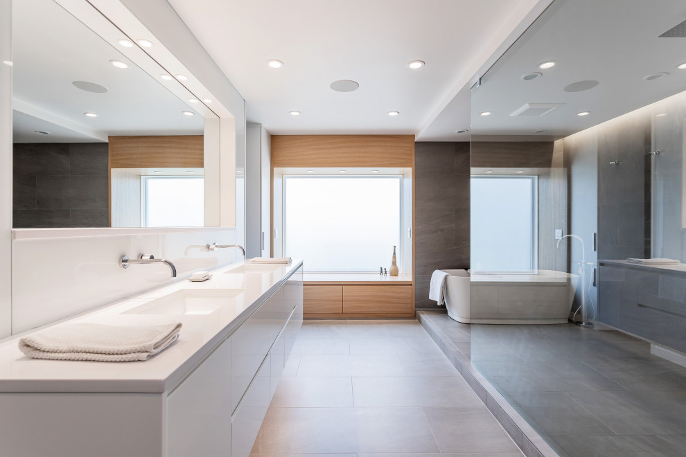 Mid-sized minimalist master gray tile and porcelain tile porcelain tile, gray floor and double-sink bathroom photo in Cincinnati with flat-panel cabinets, white cabinets, white walls, an undermount sink, solid surface countertops, white countertops and a floating vanity